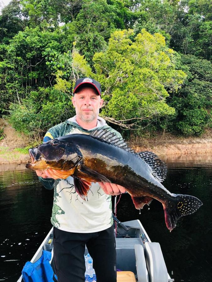 Trophy peacock bass against lush Rio Negro greenery