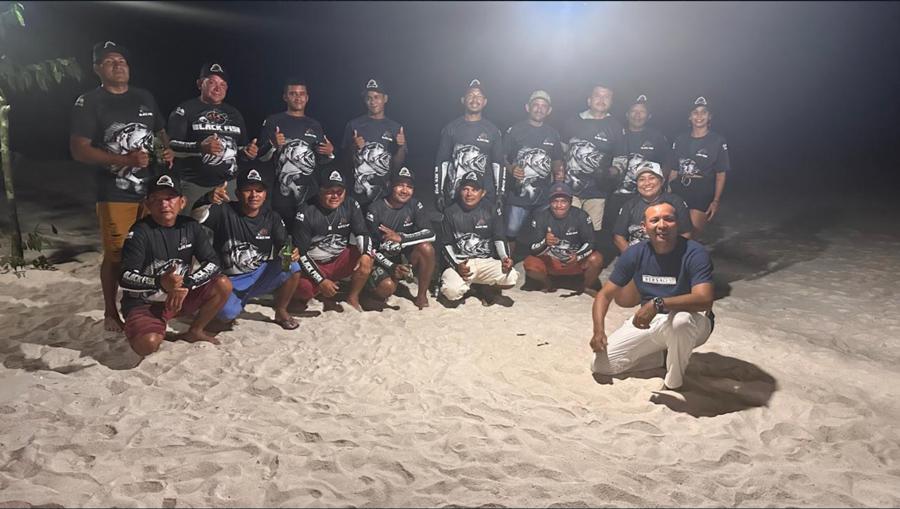 The Black Fish crew on the beach at night