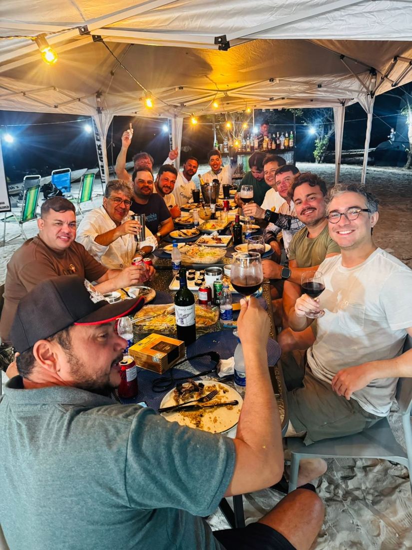 Group dinner under string lights on the riverbank