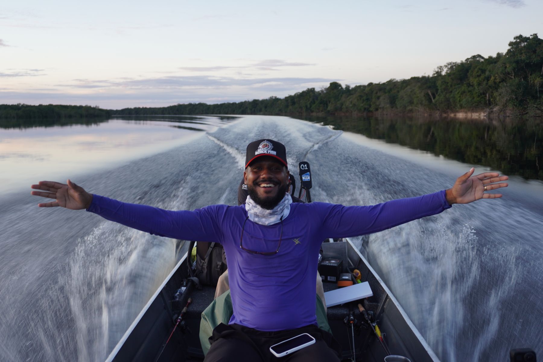 Sunrise boat run on the Rio Negro — arms wide on the bow