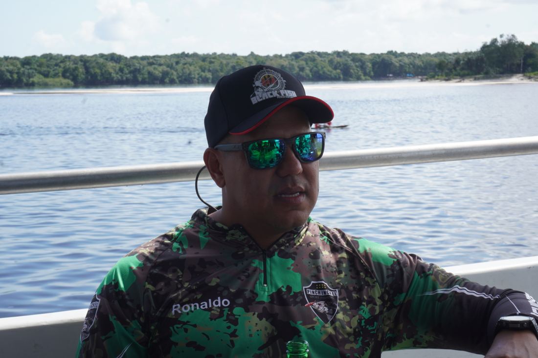Guide on the boat with the Rio Negro behind